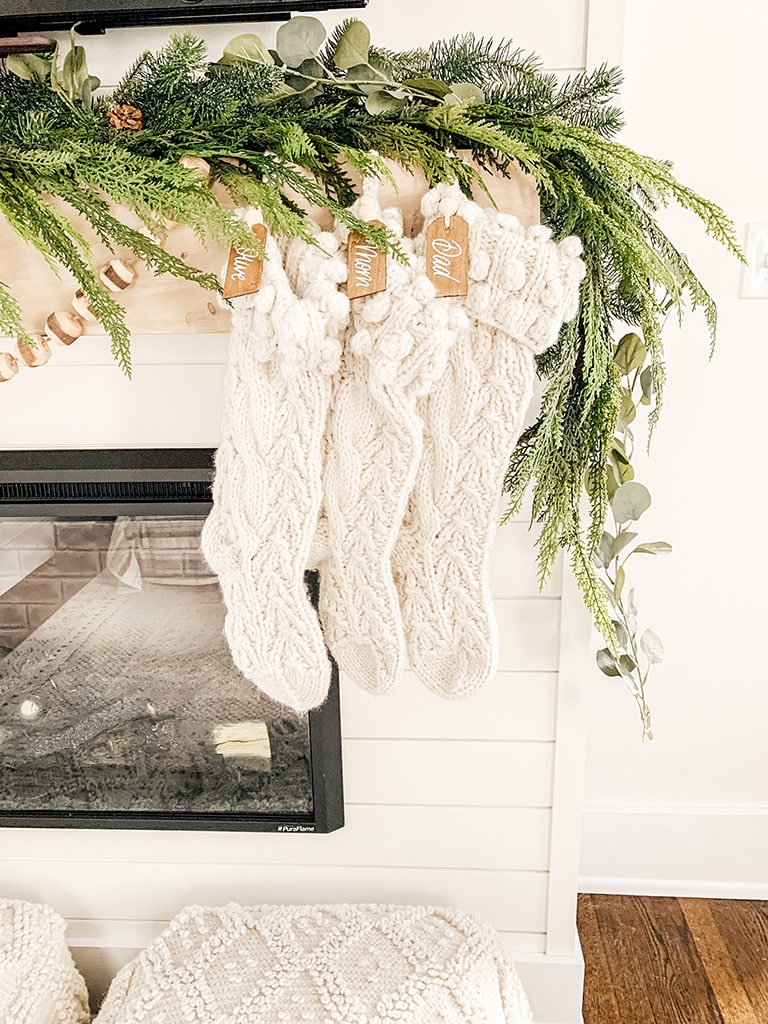 Cream color chunky knit stocking hanging on a mantel